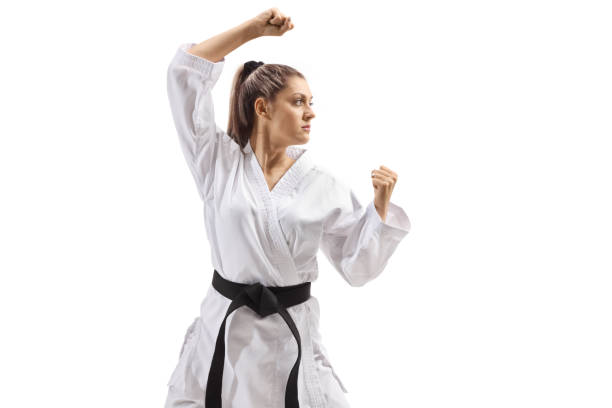 istock Young woman with black belt and kimono practicing karate kata 1299775277