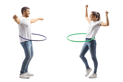 Young man and woman spinning a hula hoops isolated on white background