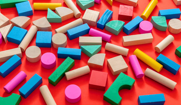istock Wooden colorful blocks on red color background 1299775846
