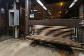 Empty wooden bench and telephone booth in covered waiting area at night in downtown Chicago