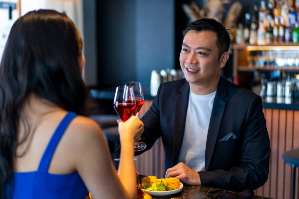 istock Handsome young Asian man having a toast with his partner at a restaurant. 1299775870
