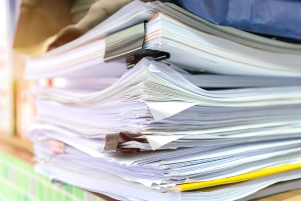 istock Business paper in offices working for arranging documents unfinished stack of document papers with pen, clip papers on busy office desk, Accounting planning budget concept 1299776037