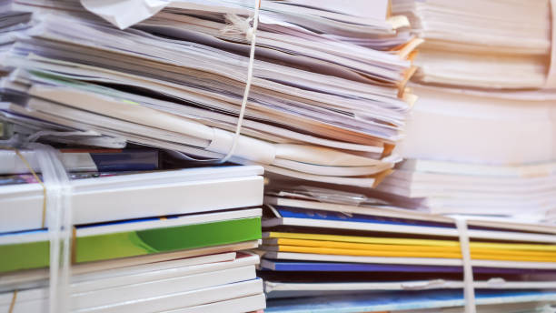 istock Overload stack messy documents of report papers for reseacrch teacher classroom planing on desk waiting to managed or approve, unorganized management stock files for check. Workload in work concept 1299776047