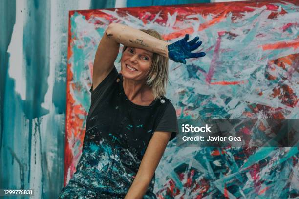 Young Woman Paints An Abstract Picture With Her Hands In Her Interior Studio Stock Photo - Download Image Now