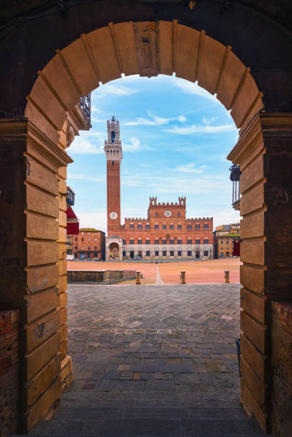 Siena, Piazza del Campo square and Mangia tower. Tuscany, Italy Siena, Piazza del Campo square, Torre del Mangia tower and Palazzo Pubblico building. Arch as a frame. Tuscany, Italy. siena italy stock pictures, royalty-free photos & images