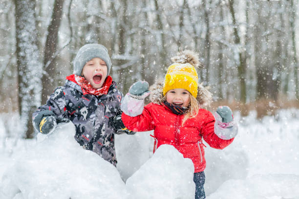 istock Boy and girl laughing in snow forest. 1299780509