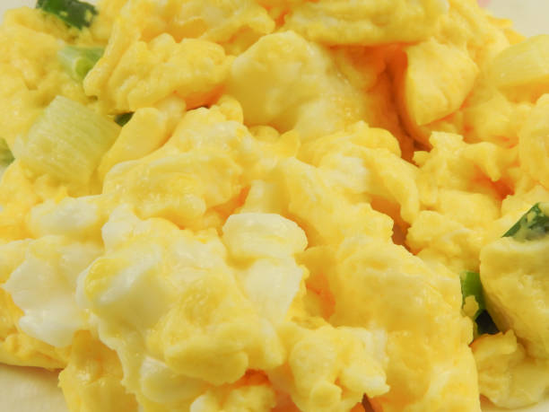 istock High angle view of yellow scrambled eggs background. 1299780613