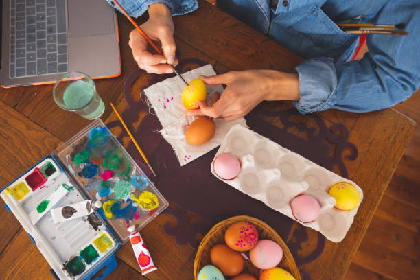 istock Woman painting Easter eggs at home 1299780739