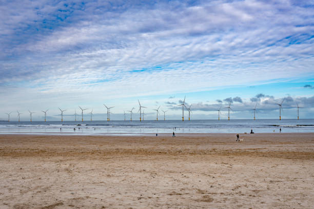 istock Wind farms beach clouds sky sea 1299781959