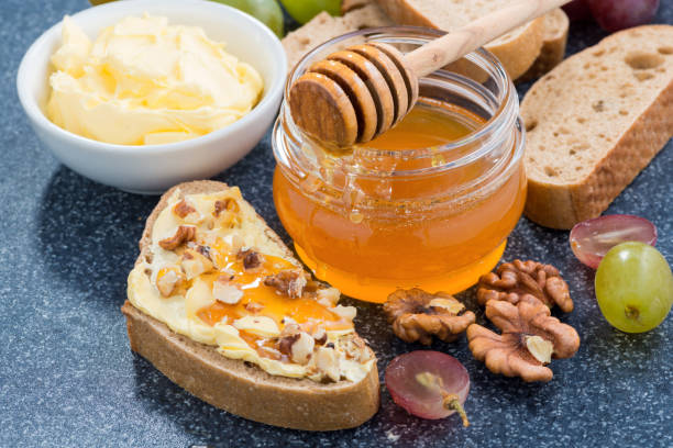 istock honey, bread with butter and grape, horizontal, top view 1299782555