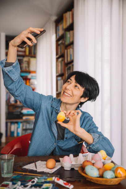 istock Woman takes a selfie with painted Easter eggs 1299782615