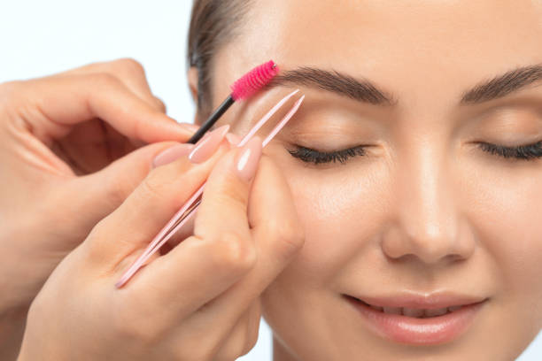istock Makeup artist combs  and plucks eyebrows after dyeing in a beauty salon.Professional makeup and cosmetology skin care. 1299782785
