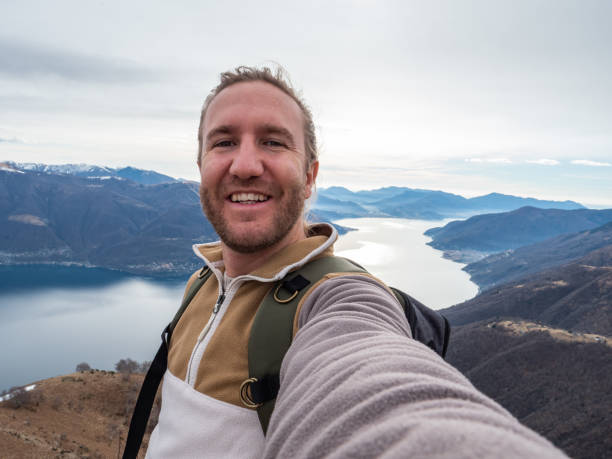 istock Cheerful young man taking a selfie portrait on mountain top 1299785428
