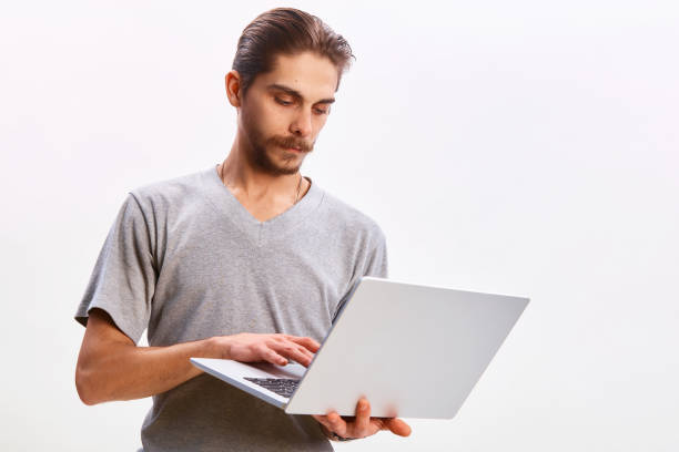 istock Portrait of a cheerful man using laptop computer over gray background 1299785806