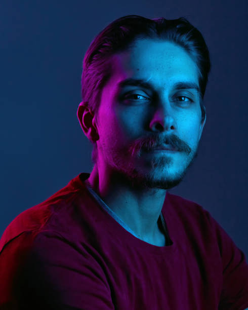 istock Beautiful caucasian young man portrait isolated on multicolored neon light backgroud. Human emotions, facial expression concept. Trendy colors. Advertising concept 1299785828
