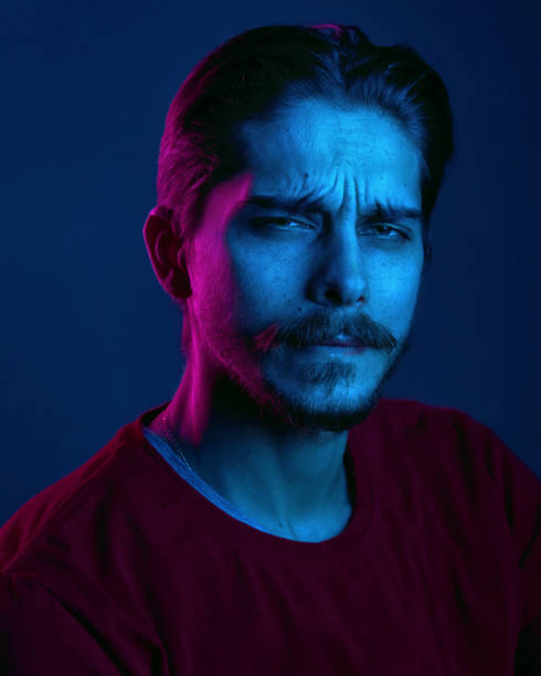istock Beautiful caucasian young man portrait isolated on multicolored neon light backgroud. Human emotions, facial expression concept. Trendy colors. Advertising concept 1299785831