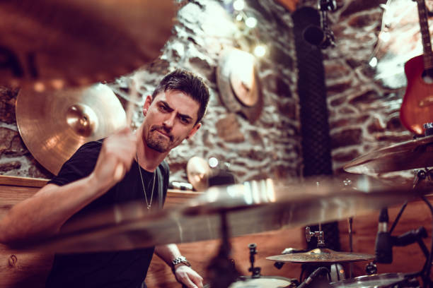 istock Male Drummer Hitting Cymbals With Full Force 1299785893