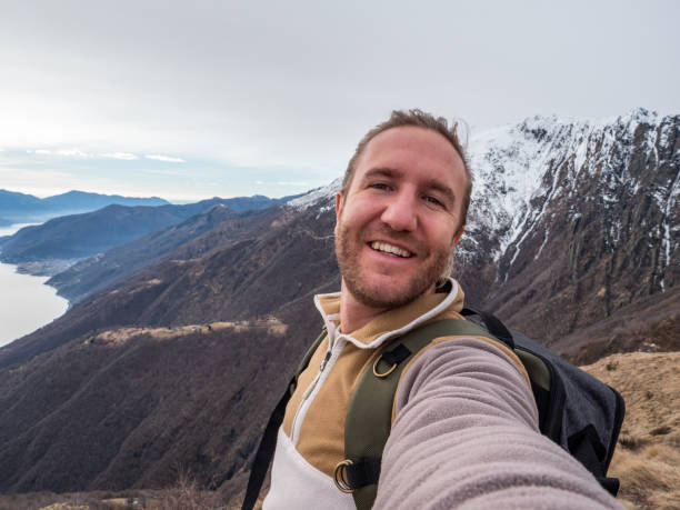 istock Cheerful young man taking a selfie portrait on mountain top 1299785904