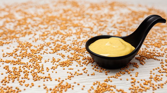 Mustard and mustard seeds on wooden background