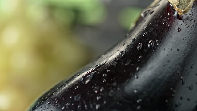 SLO MO LD Drop of water gliding down an aubergine
