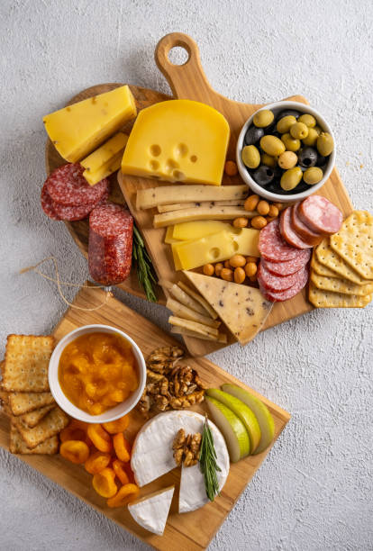 istock Different types of cheeses  and cold cut meats. Top view on a white background. Assorted cheeses with nuts, cracker,  olives, salami  and rosemary. 1299787241