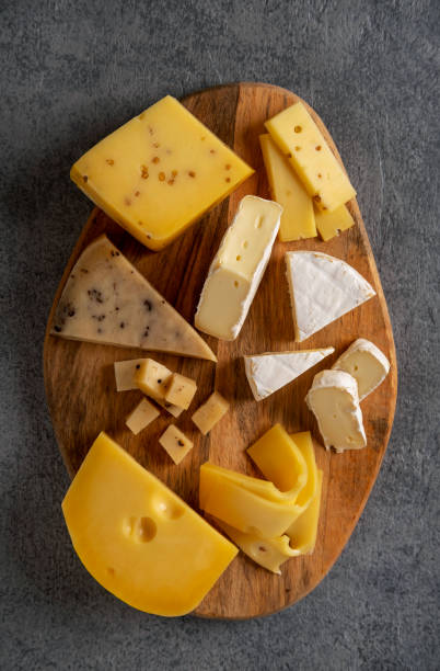 istock Cheese platter on wooden board. Cheese background. Closeup. 1299787270