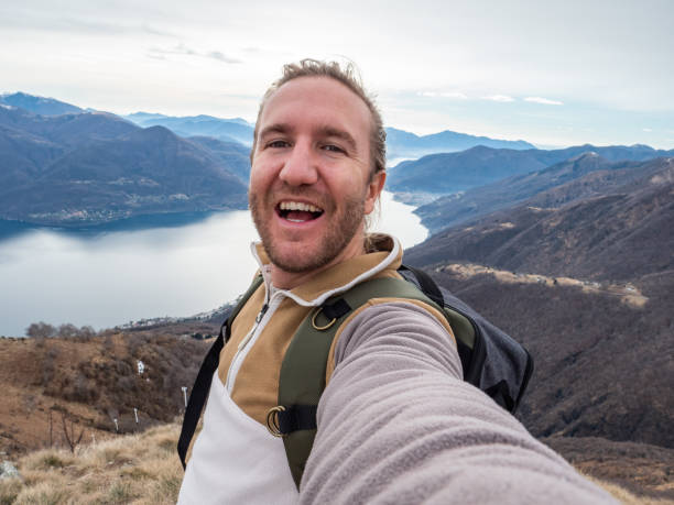 istock Cheerful young man taking a selfie portrait on mountain top 1299787324