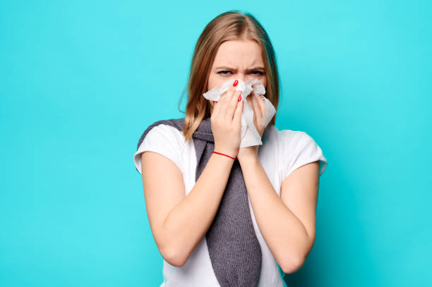 istock Woman blows her nose into a napkin. 1299787395