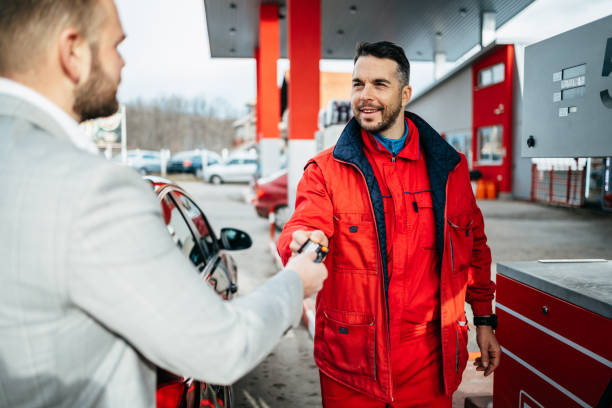 istock Young man using credit card to make a payment for refueling car on gas station. 1299788281