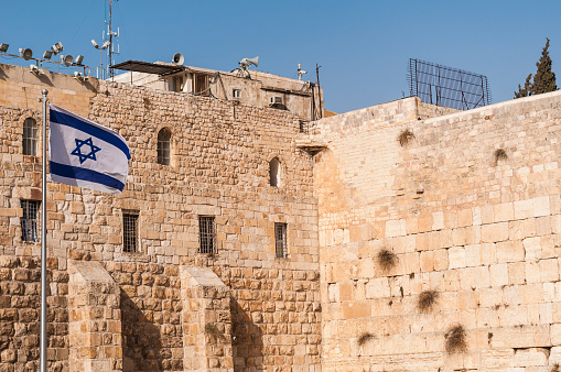 An Israeli flag flies from a flagpole at the Western Wall plaza in Jerusalem's Old City
