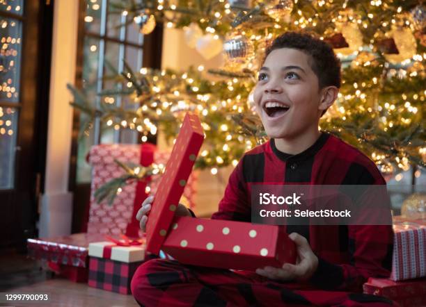 Mixed Race Teenager Boy Opening Christmas Presents Stock Photo - Download Image Now - Child, Christmas Present, Opening