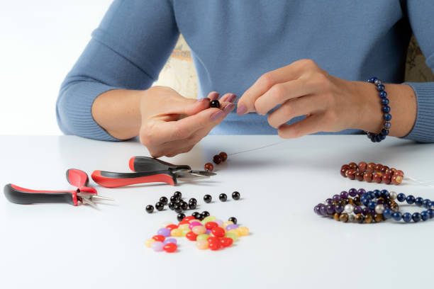 fabricação de joias. pulseiras de produção e colares de contas multicoloridas. - necklace jewelry bead homemade - fotografias e filmes do acervo