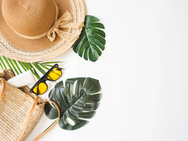 istock Summer accessories concept from sunglasses, straw hat and tropical palm leaf branches on white background with empty space for text. 1299790206