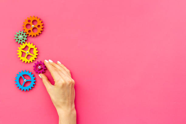 istock Teamwork concept. Hand connecting gears into puzzle - symbol of working mechanism 1299791467