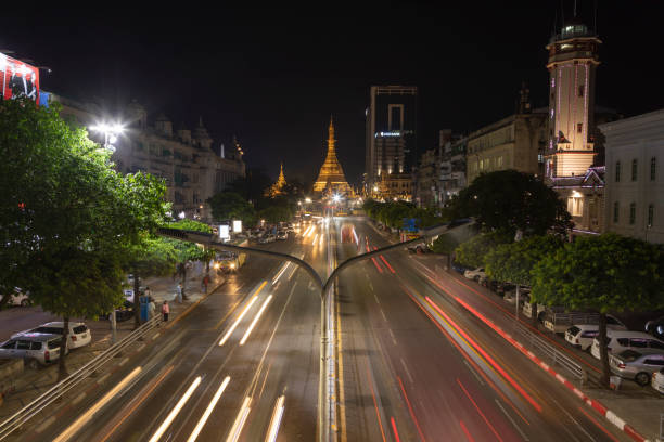 Night traffic towards Sule Pagoda Buddhist temple, Yangon, Myanmar. Yangon, Myanmar - December 19, 2019: Detail of night traffic towards Sule Pagoda Buddhist temple and stupa, from the Sule Paya Road Pedestrian Bridge, in long exposure photography. sule pagoda stock pictures, royalty-free photos & images