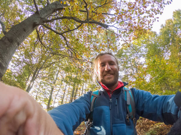 istock Cheerful man taking a selfie portrait in the forest 1299795024