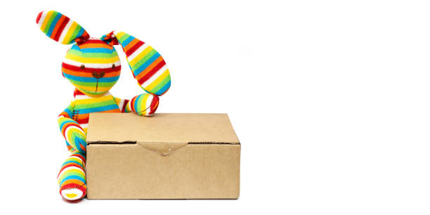 istock Easter rabbit with shipping carton, delivery packaging box isolated on white background. Easter online mail shopping sale. Copy space, front view. 1299795263
