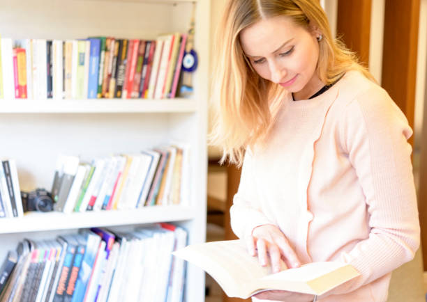 istock Blond woman front of the bookshelf 1299796561