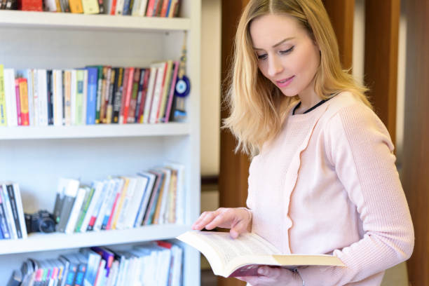 istock Blond woman front of the bookshelf 1299796612