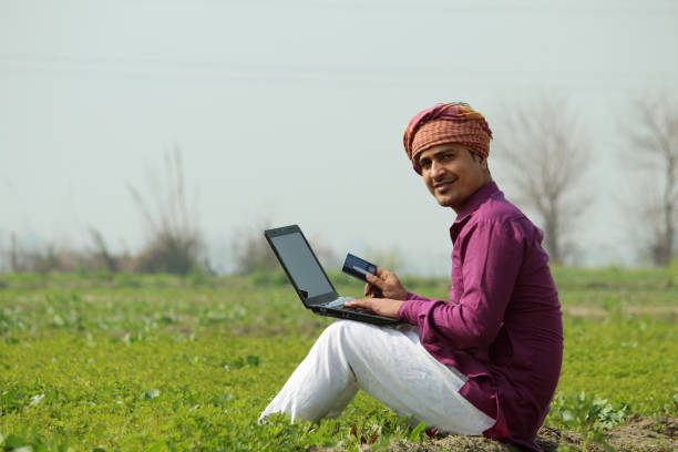 istock happy indian farmer using laptop and bank card 1299796731