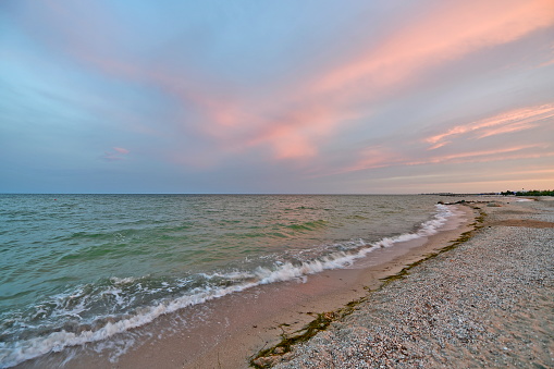 Beautiful evening sunset on the beach of the sea of azov. Colorful colors of sky and sea.