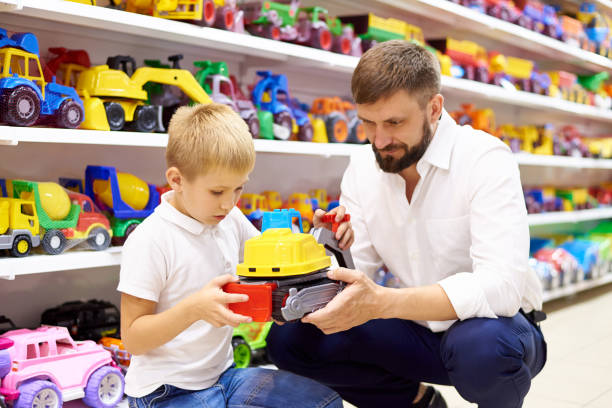 Father and son in a toy store. Father and son in a toy store. toy store stock pictures, royalty-free photos & images