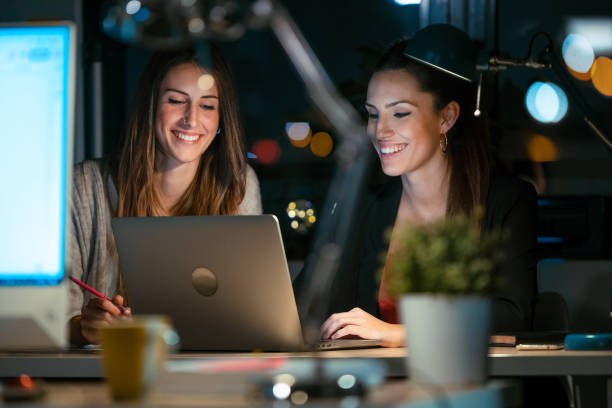 istock Two smart business women working together with laptop while talking in the office. 1299800322