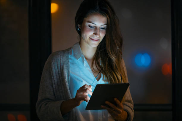 istock Smart pretty business woman taking a break while cheaking her digital tablet standing in the office. 1299800537