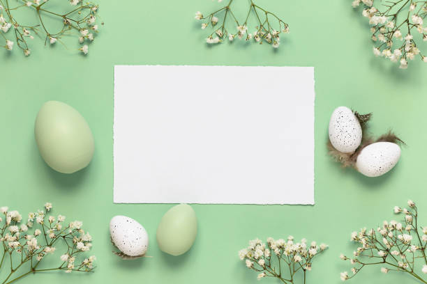 istock White and green Easter eggs, spring flowers on a green background. Flat lay, copy space. 1299800540