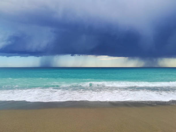 The tide coming onto pink looking sand in the Bahamas as a storm approaches.