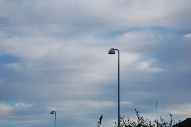 istock Two street lamps against the sky - low angle view. 1299801751
