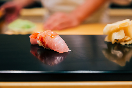 Japanese Omakase in Edo Style: Close up Otoro (Fatty Tuna) Sushi served on glossy black plate. Japanese traditional luxury meal.