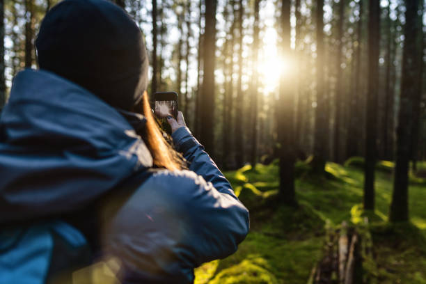 istock Woman hiking outdoors in springtime forest: selfie with mobile phone 1299803281