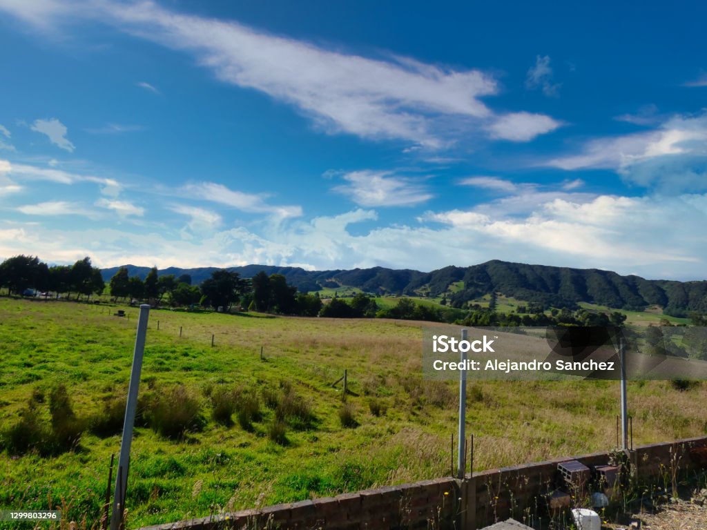 Fields in front of a brick courtyard Grass old fields and large mountains in front of a brick courtyard. Abandoned Stock Photo